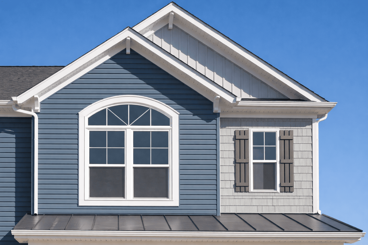Blue siding home exterior with decorative arched window and roof gutter system by Bluebeam Group in Orange County NJ